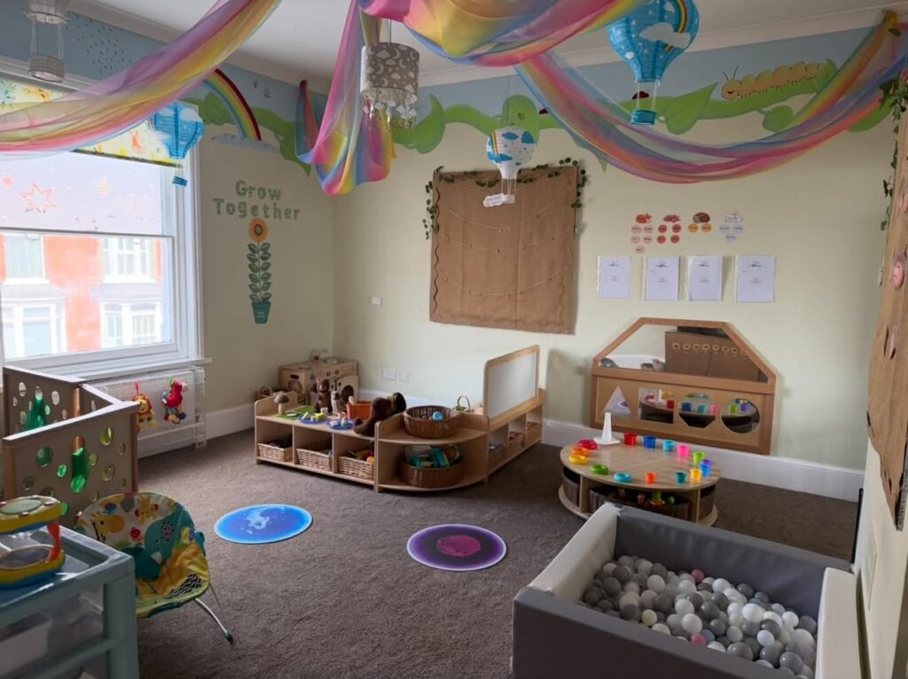 Ball pit and sensory play area in the Baby Stars room, with rainbow fabric hanging from the ceiling