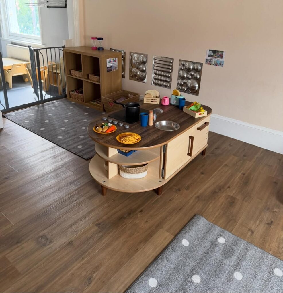 Play kitchen and wall of mirrored sensory panels in the Big Stars room