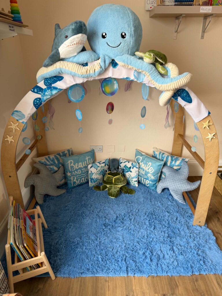Ocean-themed reading corner with soft sea creatures and blue cushions