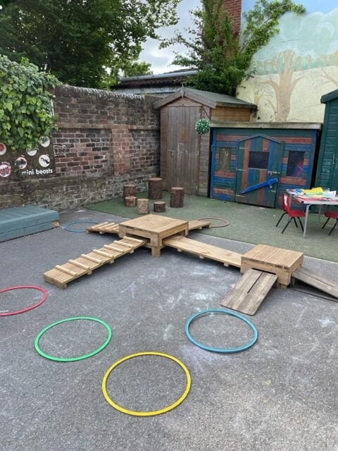 Wooden stepping blocks, log stumps and coloured hoops beside the garden playhouses